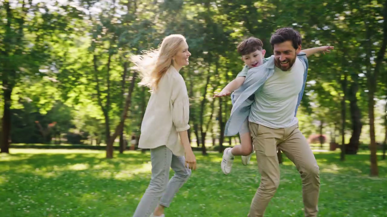 Happy Family Running and Playing in Park