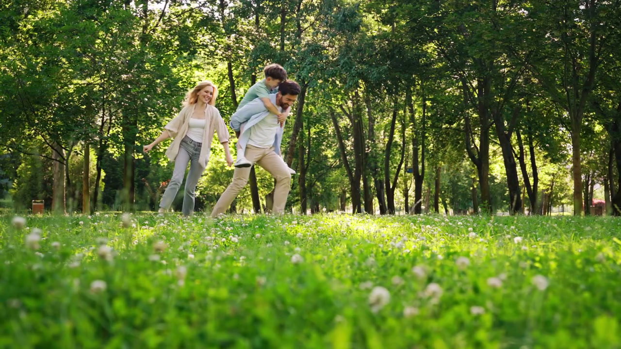 Family Playing in Park with Piggyback Ride