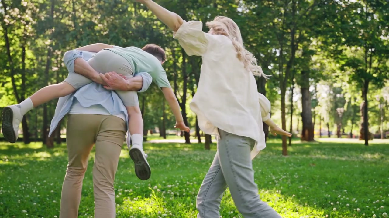 Happy Family Piggyback Ride in Park