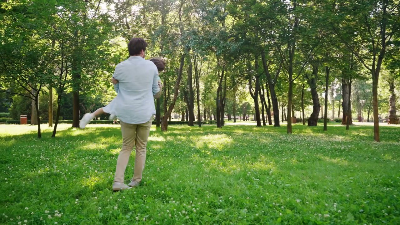 Father Spinning Son in Park