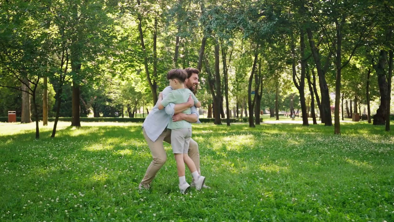 Father And Son Hugging In Sunny Park