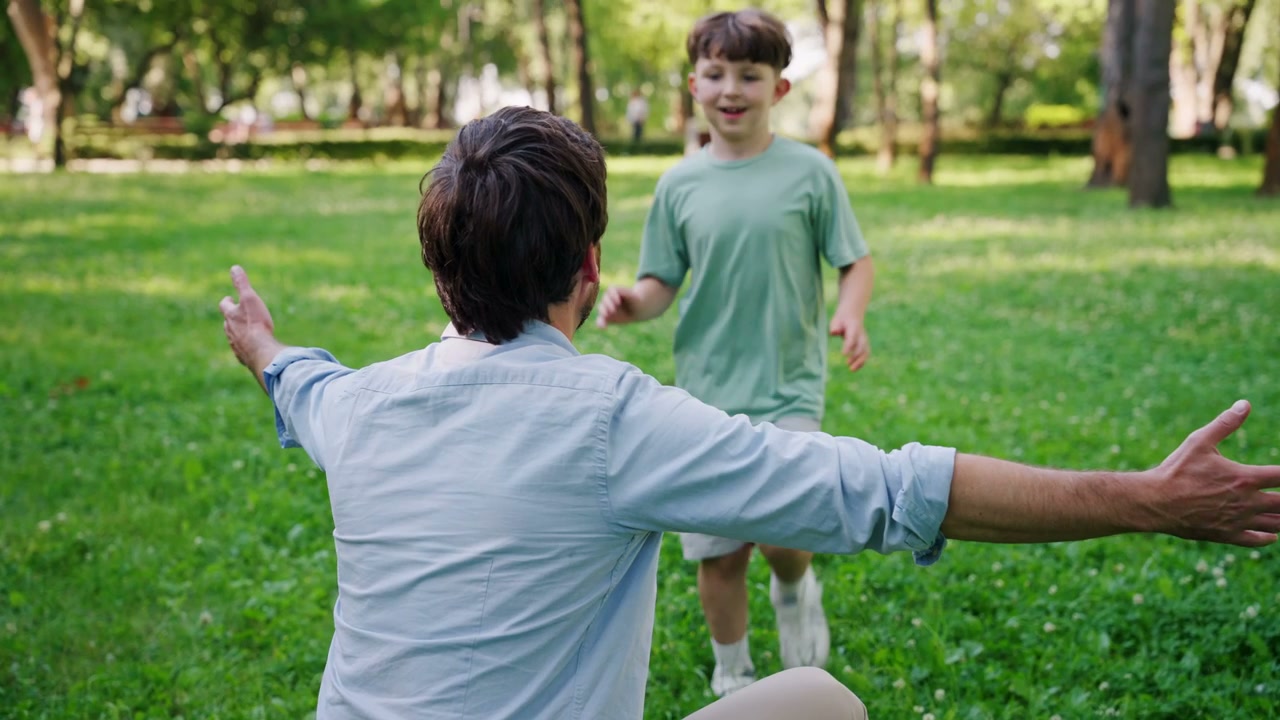 Boy Runs to Father for a Hug in Park