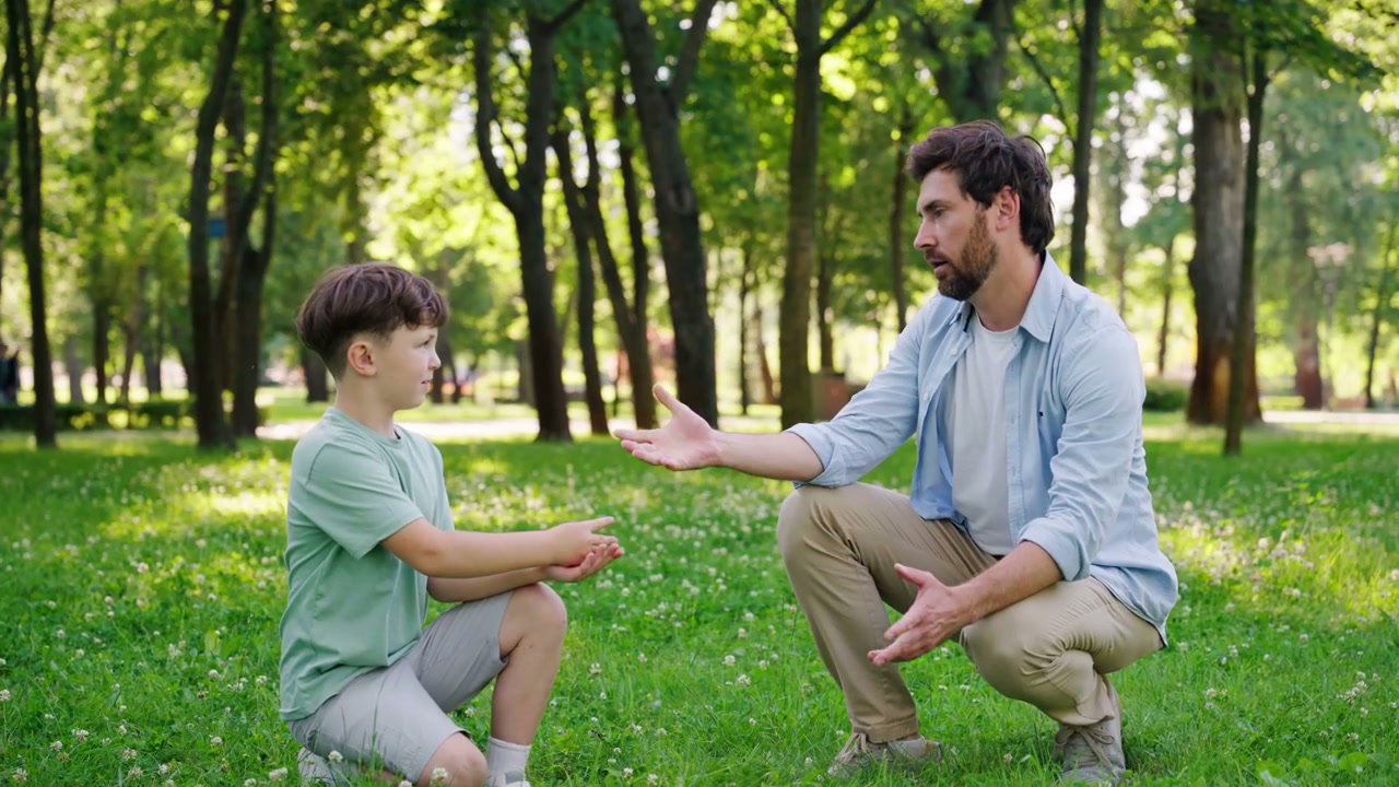 Father and Son Playing Rock-Paper-Scissors in Park