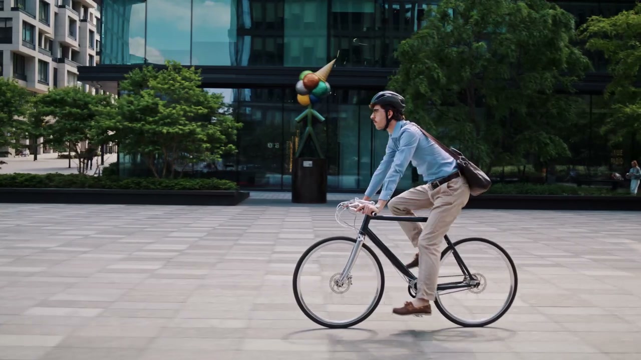 Businessman Cycling Through City Square