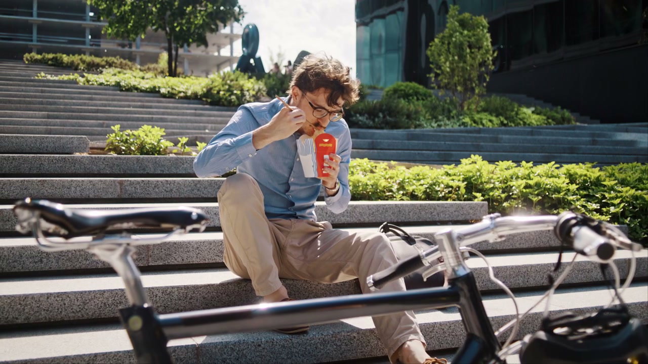 Cyclist Eating Lunch on Urban Stairs