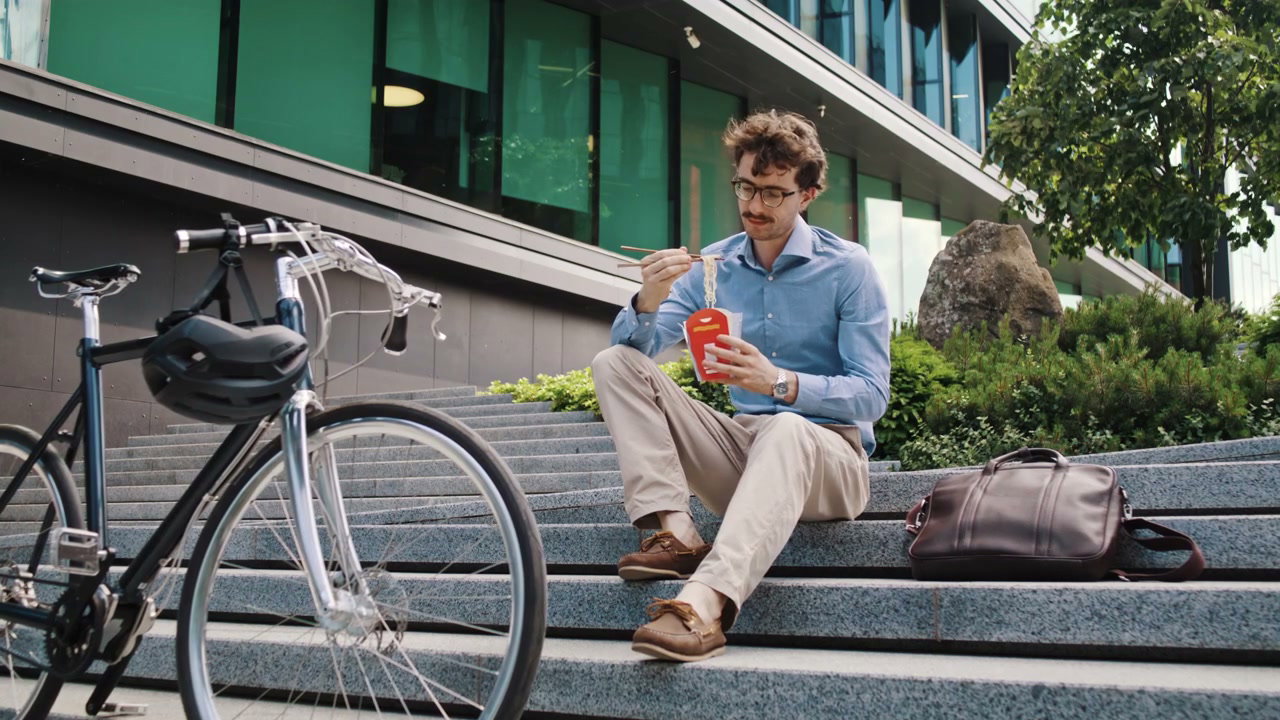 Businessman Eating Noodles by Bicycle Outdoors