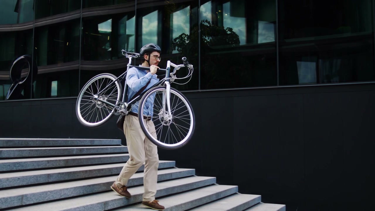 Businessman Carrying Bike Up City Stairs