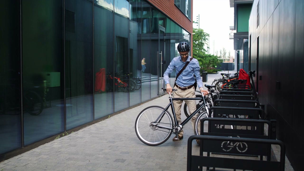 Businessman Cycling From Modern Office Building
