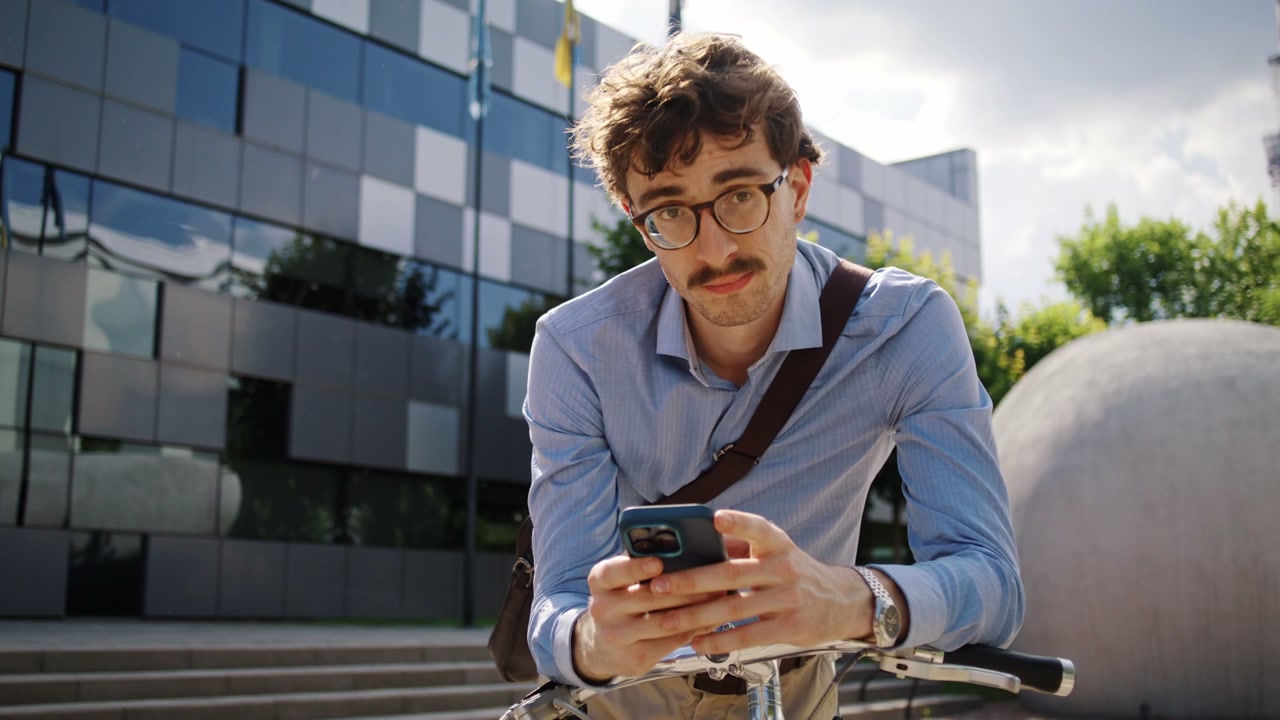Businessman Uses Phone Leaning on Bicycle