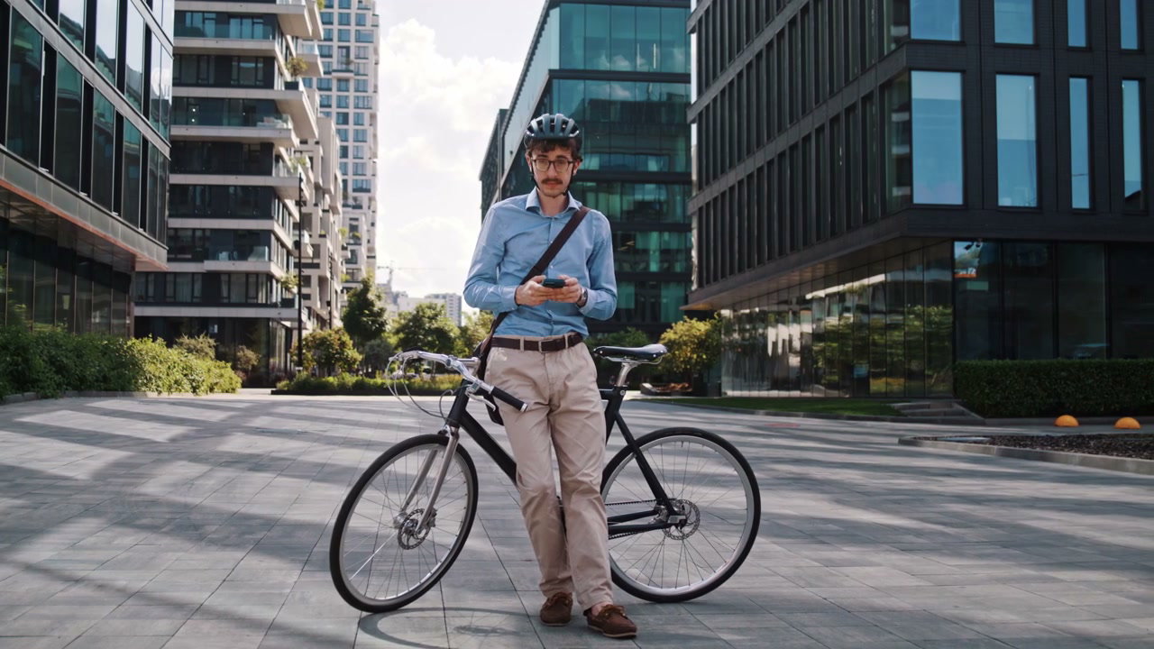 Businessman With Bicycle Using Phone In City