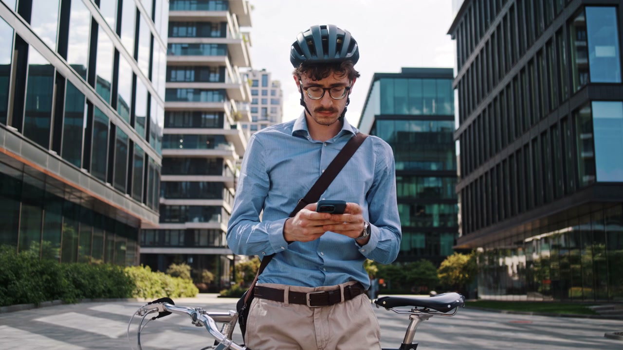 Businessman on Bike Checks Phone in City
