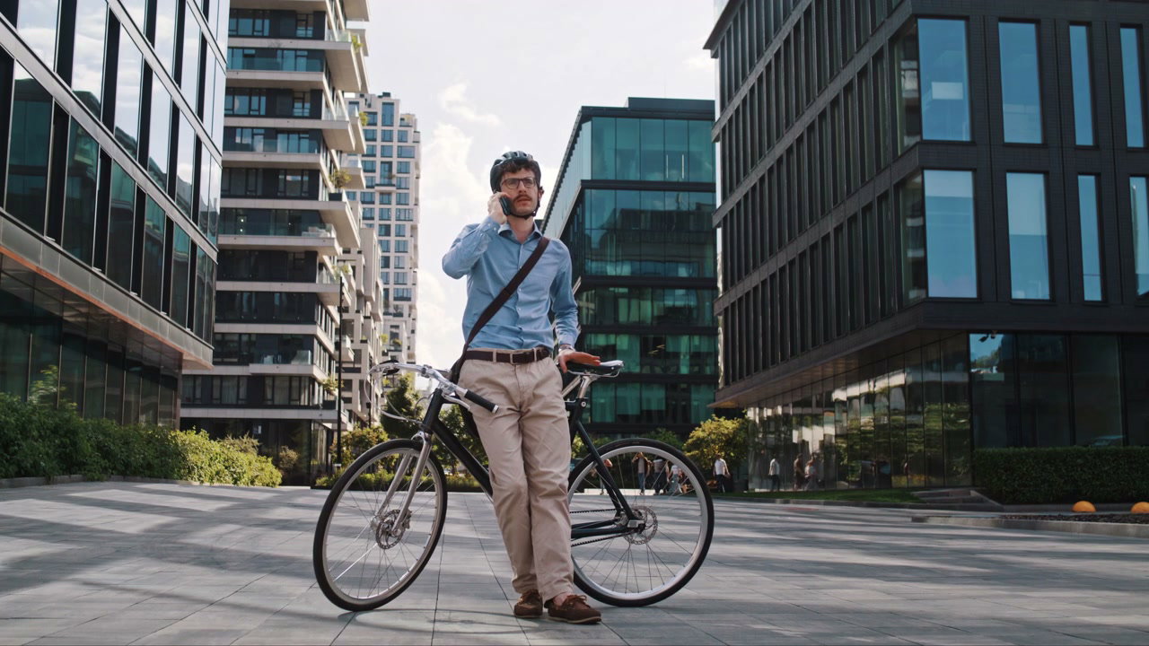 Businessman Talking on Phone with Bicycle in City