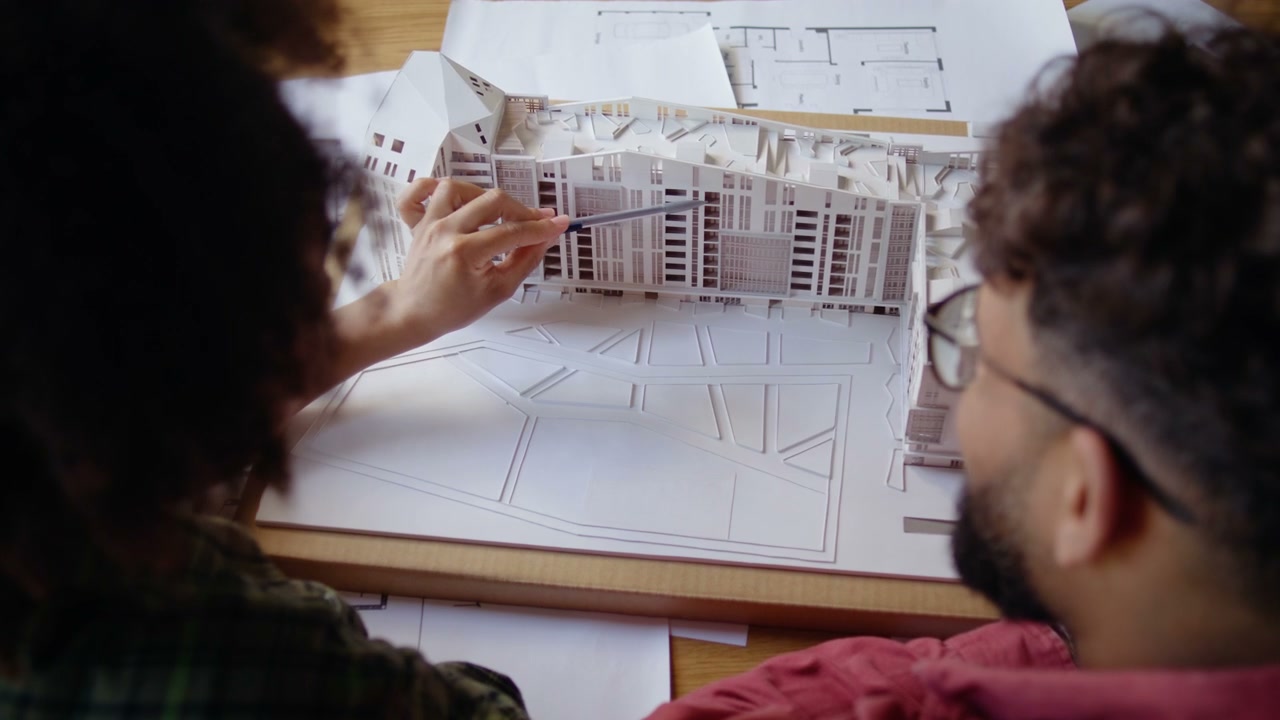 Two Architects Discussing Building Model