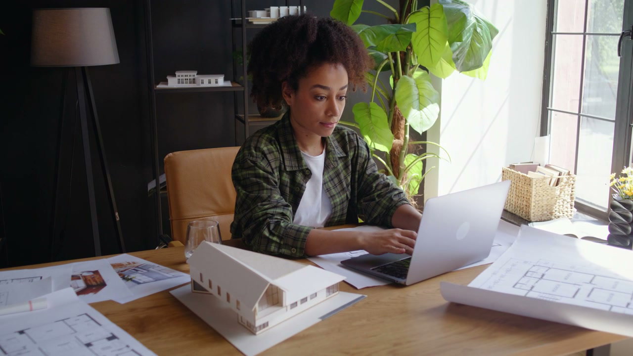 Architect Working on Laptop with Blueprints