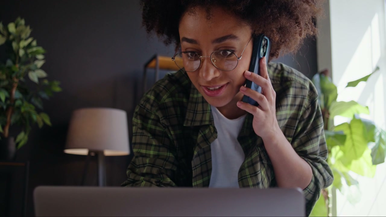 Woman Talking on Phone while Using Laptop