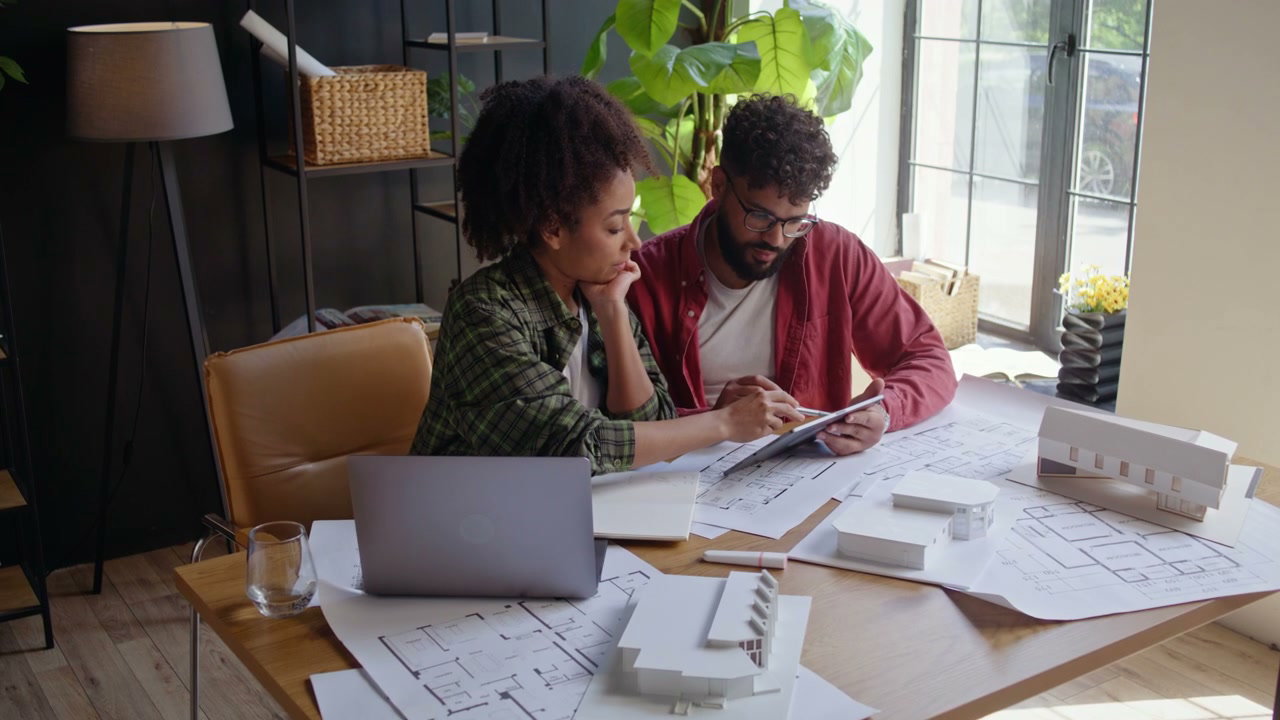 Two Architects Collaborating on Blueprints