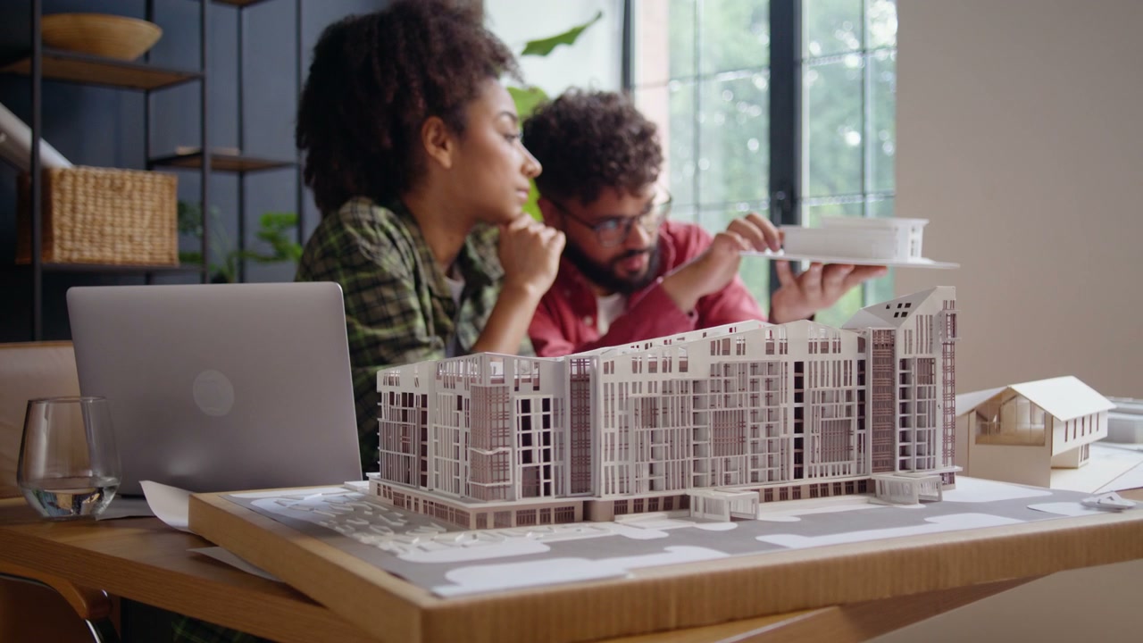 Two Architects Examining Building Models