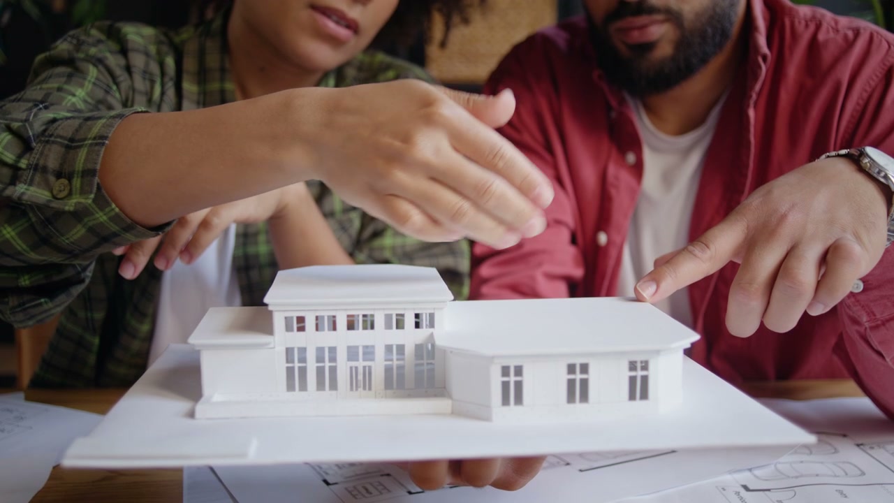 Architects Pointing at House Model