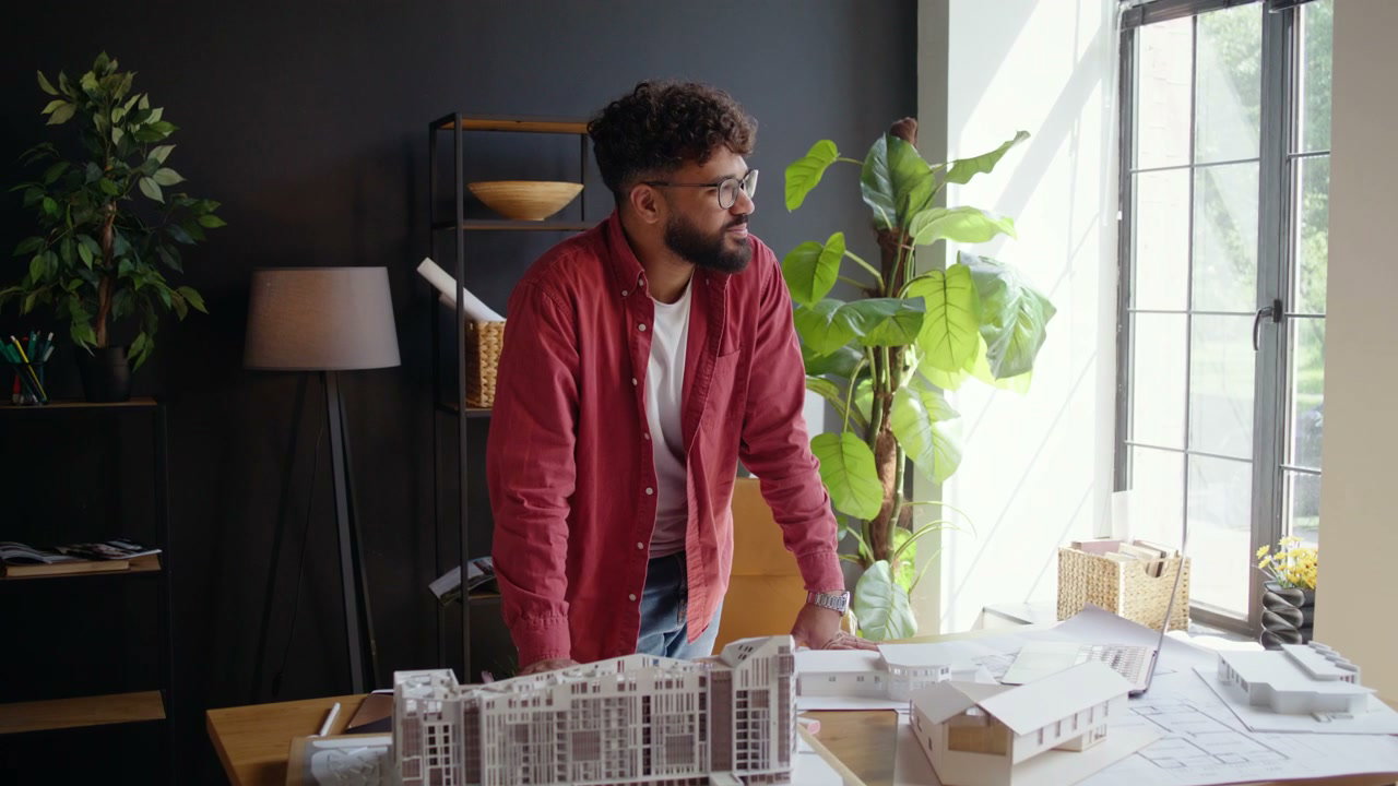 Young Architect Smiling at His Office Desk