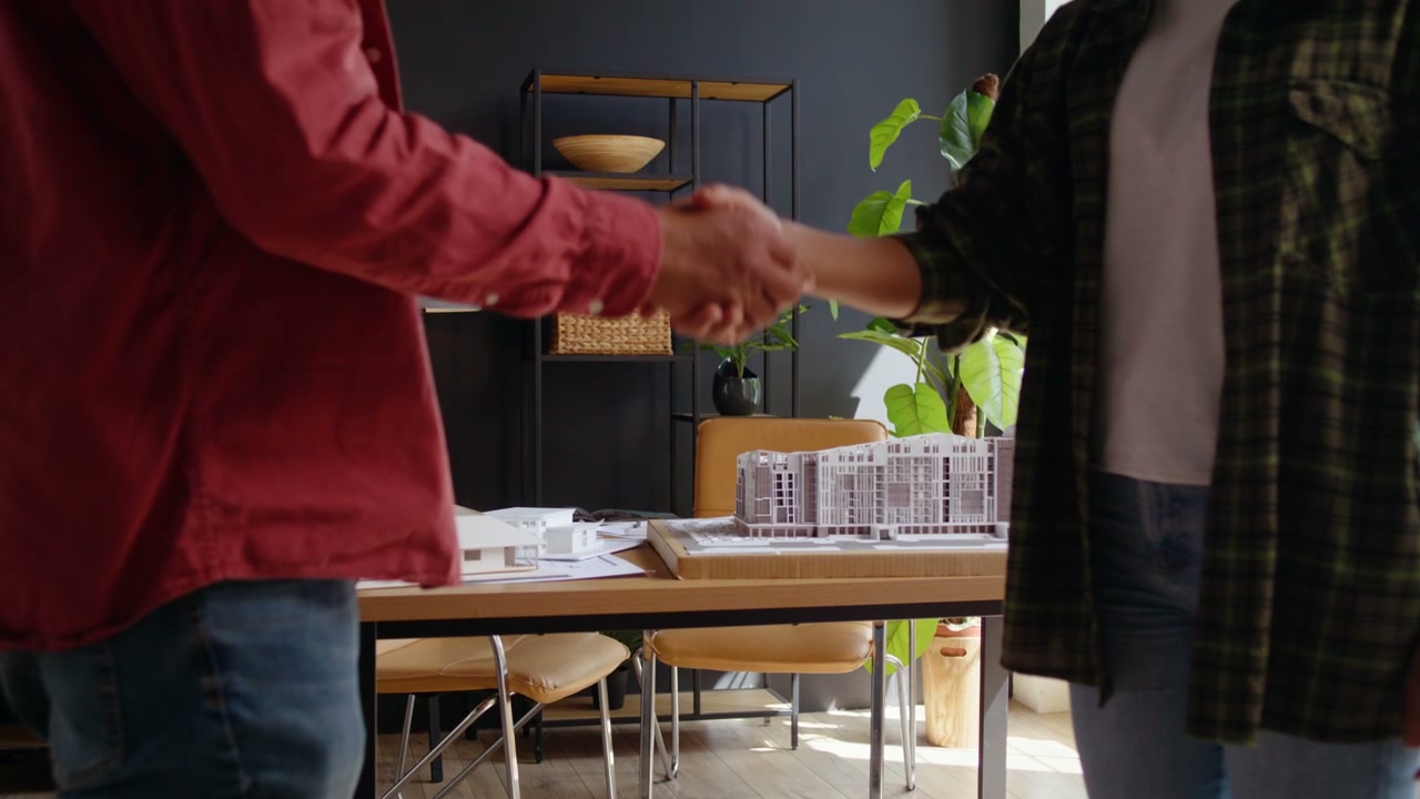 Architects Handshake Over Building Models
