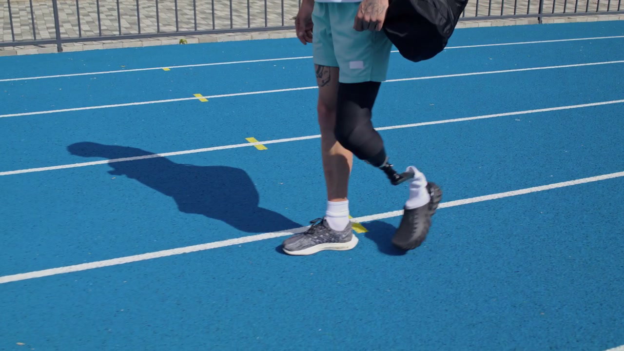 Athlete with Prosthetic Leg Walking on Track