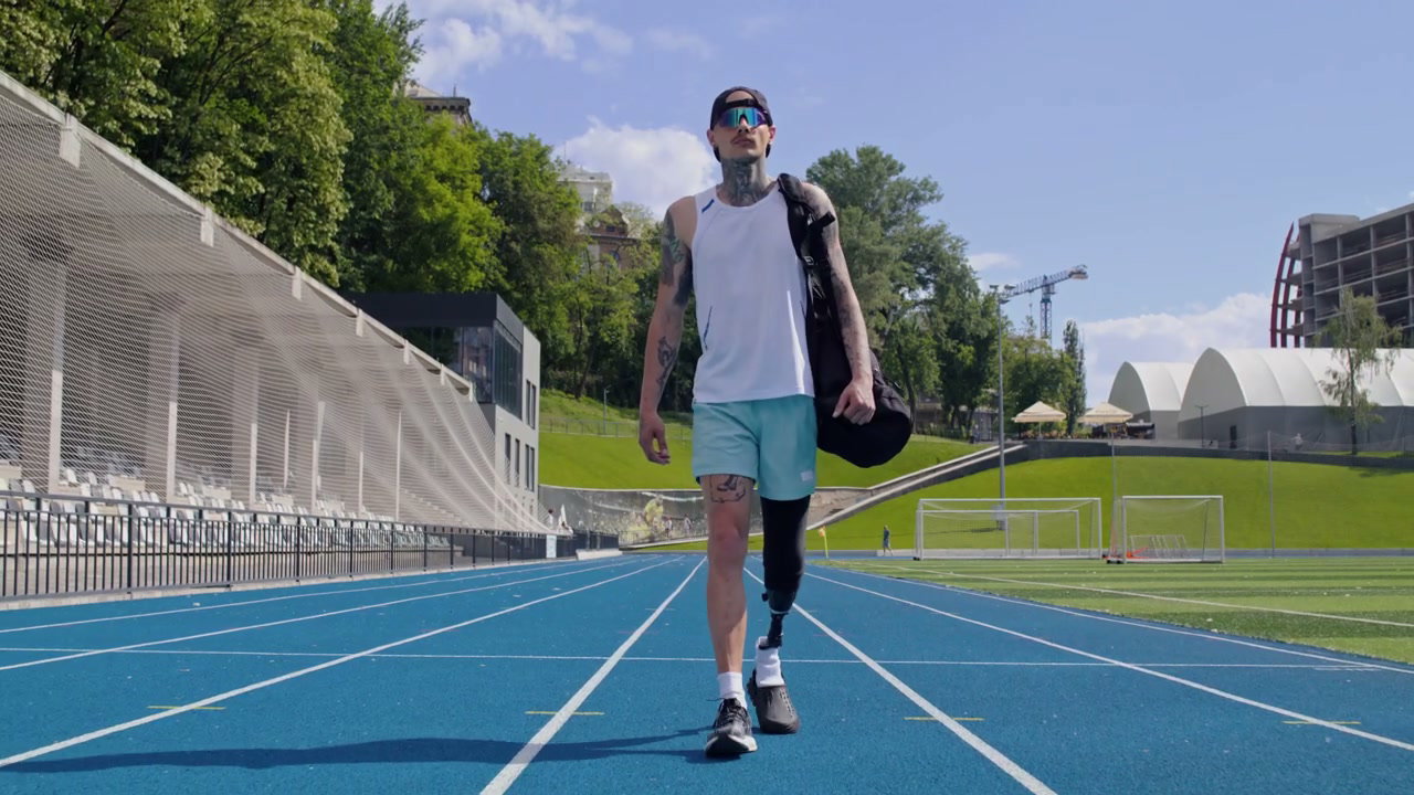 Man with Prosthetic Leg Walking on Running Track