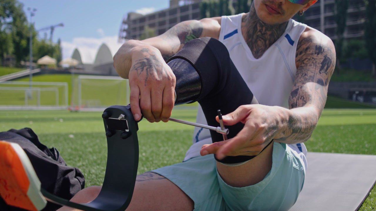 Tattooed Athlete Adjusting Prosthetic Running Blade