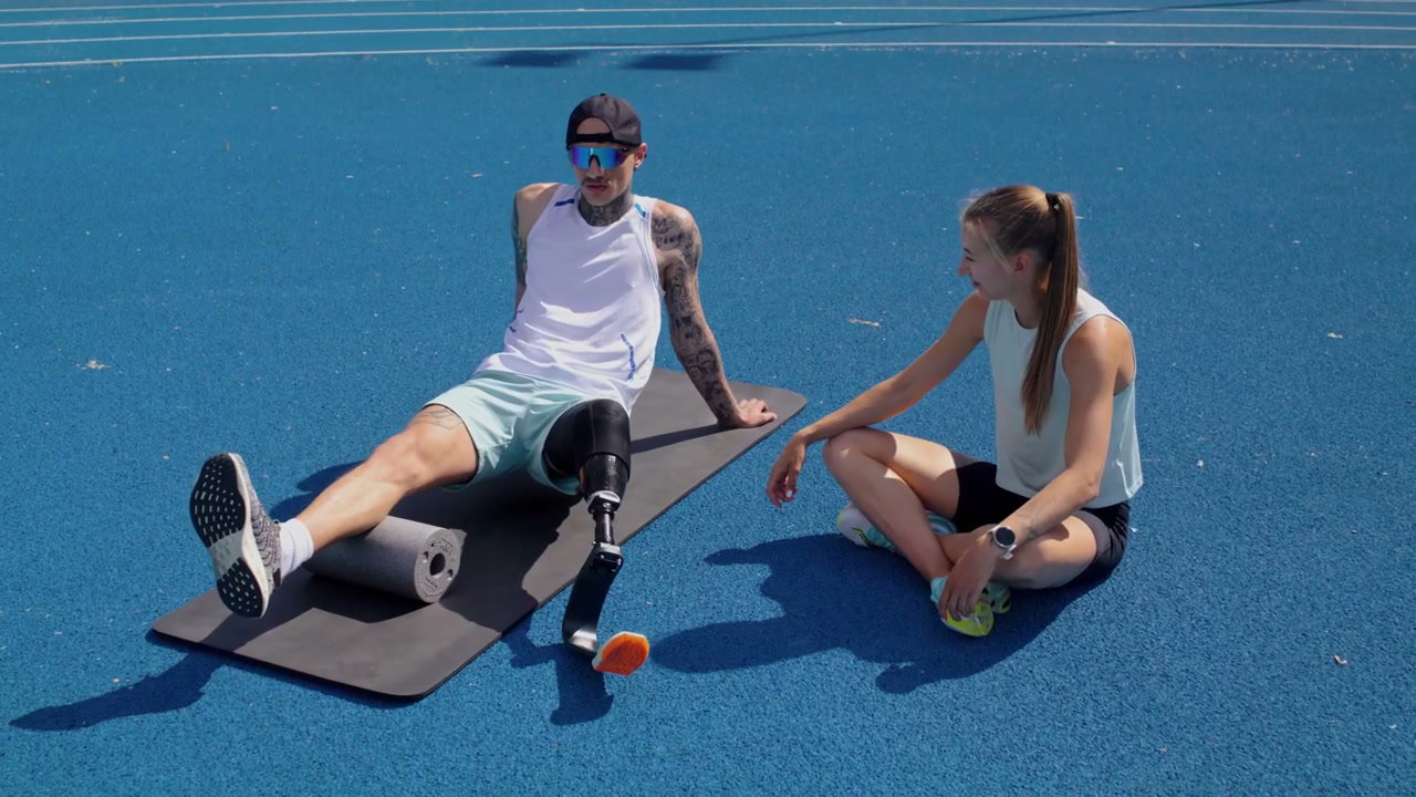 Para Athlete Foam Rolling Leg on Blue Track
