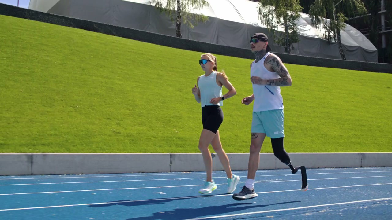 Prosthetic Runner and Woman Jogging on Track