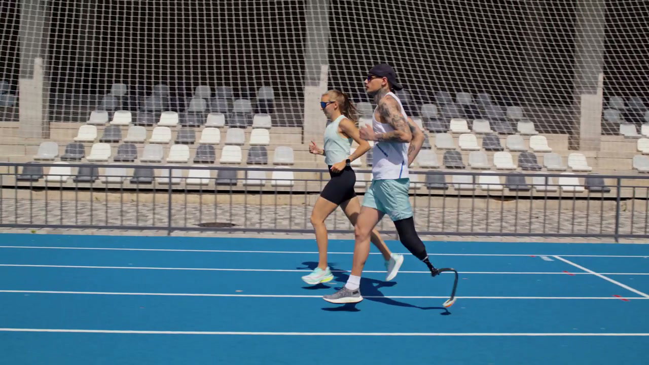 Prosthetic Runner and Woman Jogging on Track