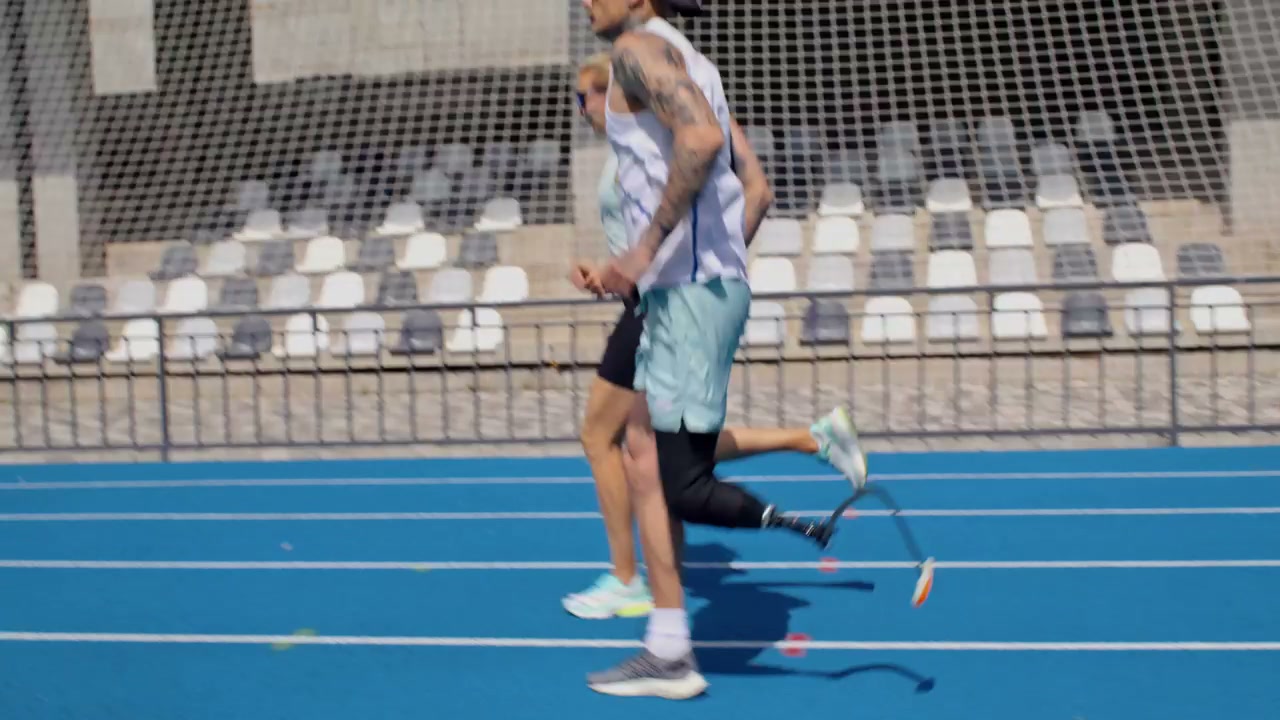 Athletes Running with Prosthetic Leg on Track