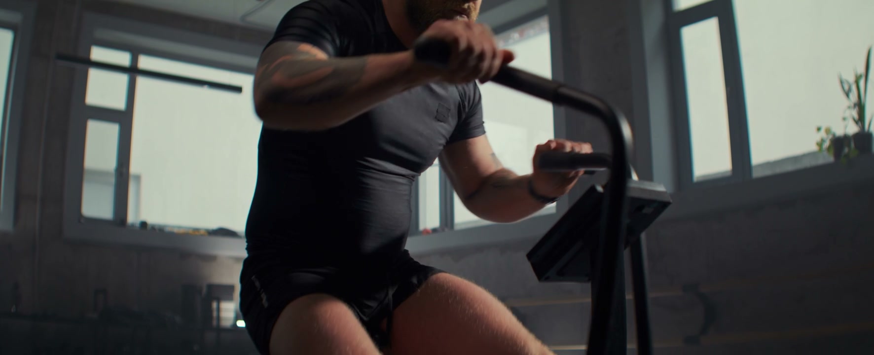 Man Training On Air Bike In Gym
