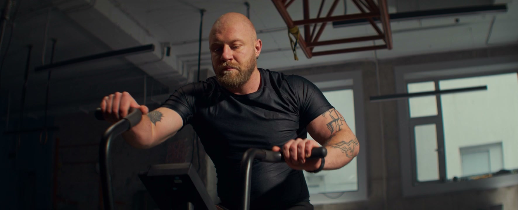 Man Exercising on Air Bike in Gym