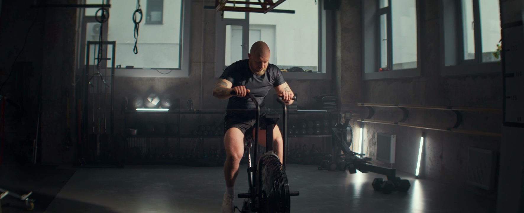 Athlete Training on Air Bike in Gym