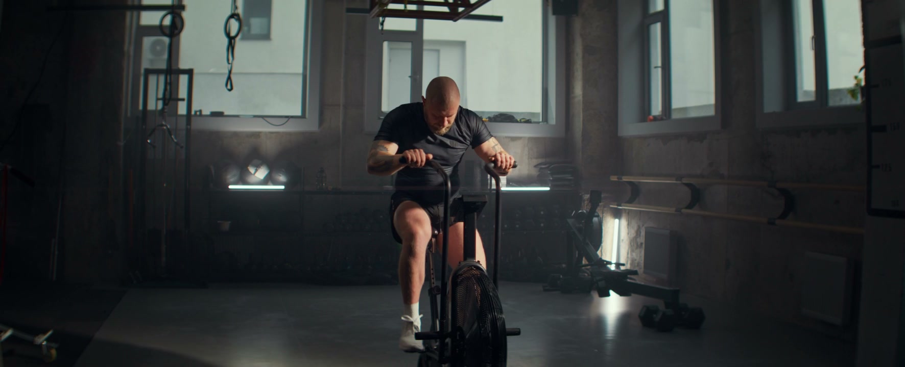 Athlete Training on Air Bike in Gym