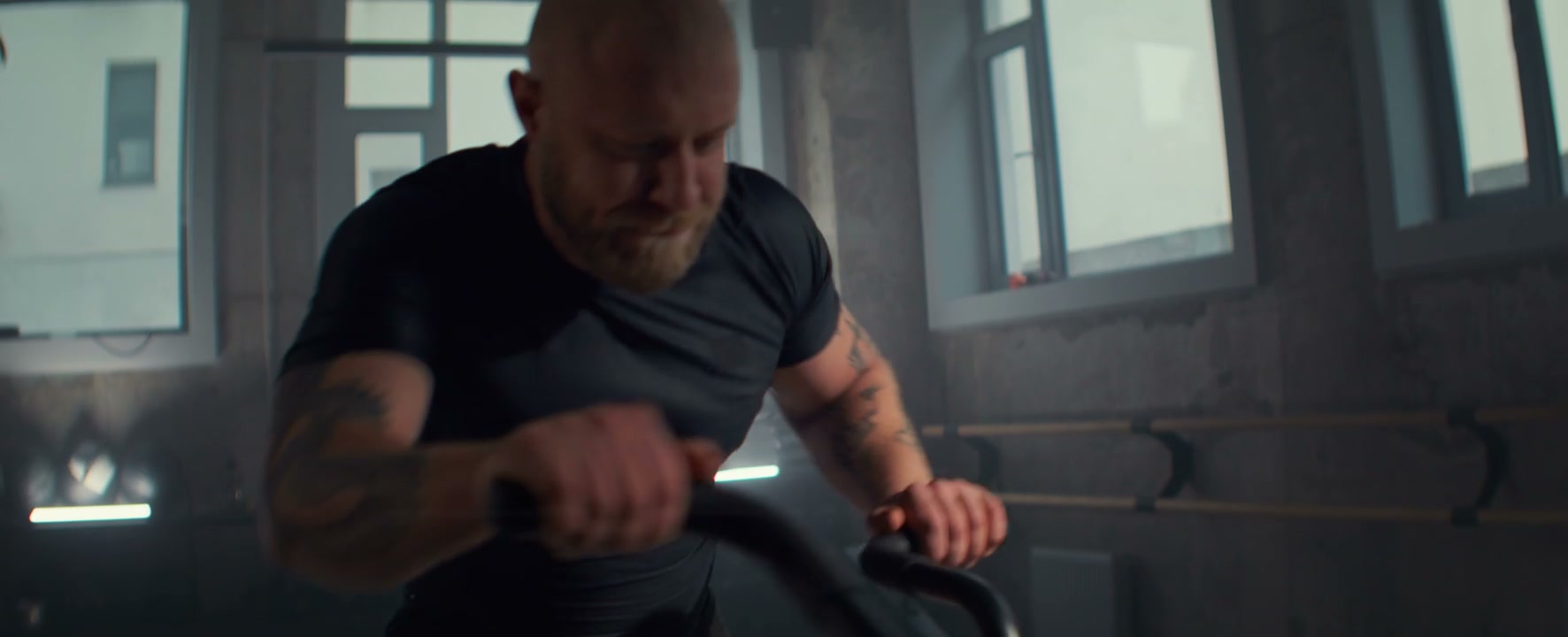 Man Training on Air Bike in Gym