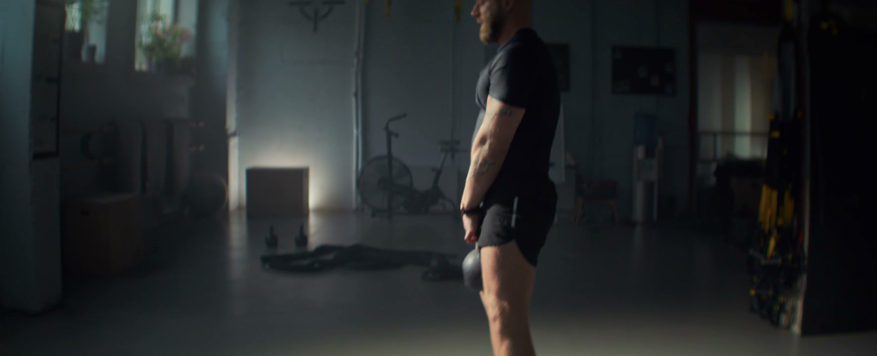 Man Performing Kettlebell Swings in a Gym