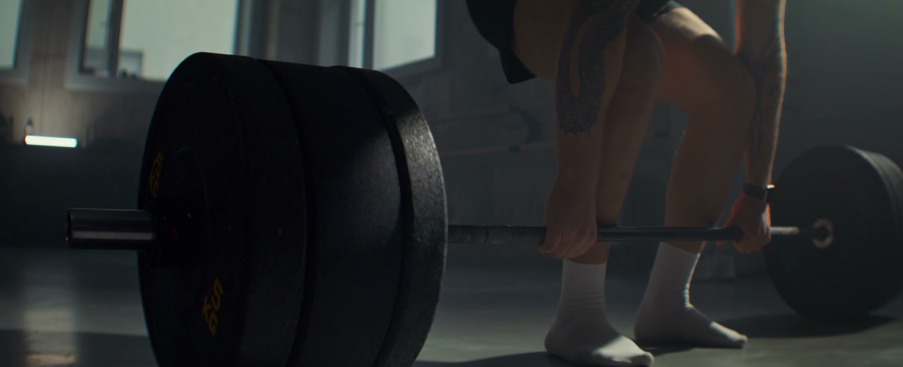 Person Deadlifting Heavy Barbell in Gym