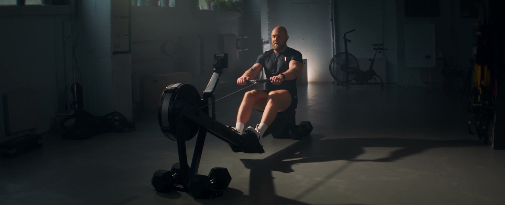 Man Exercising on Rowing Machine in Gym