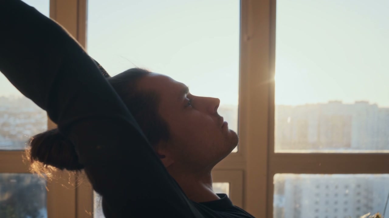 Man Stretching in Sunny Yoga Studio