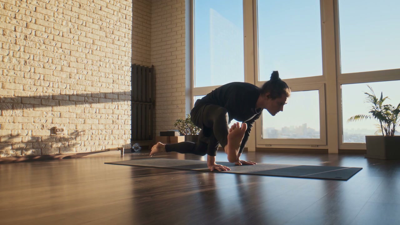 Man Practicing Yoga Arm Balances in Studio