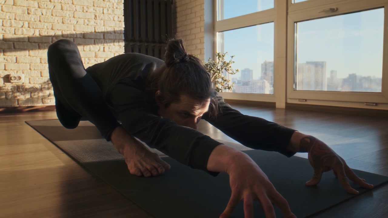 Man Performing Crow Pose in Yoga Studio