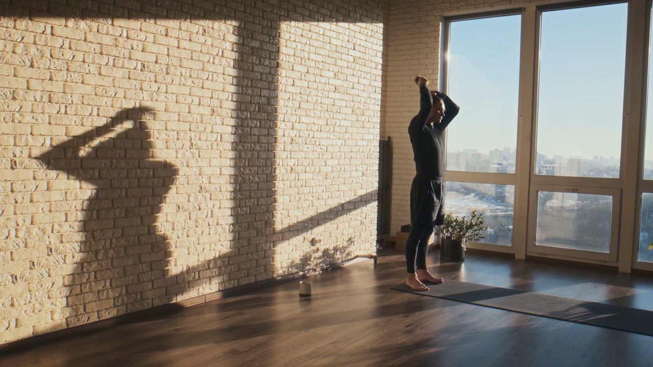 Man Warming Up in Sunny Yoga Studio
