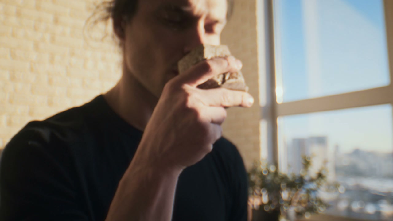 Man Sips From Ceramic Cup In Sunny Studio