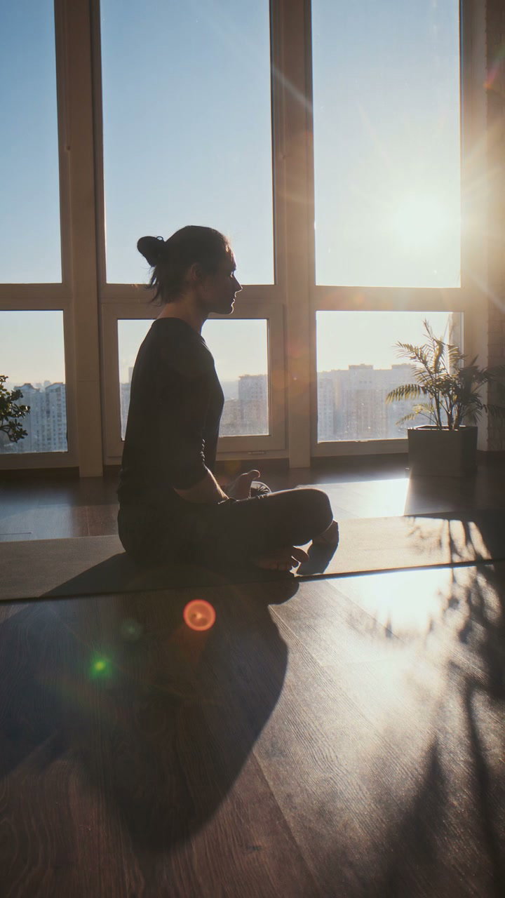 Person Meditating in Sunny Yoga Studio