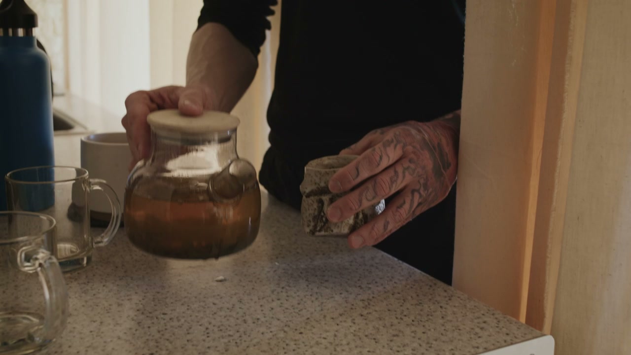 Person Pouring and Sipping Hot Tea