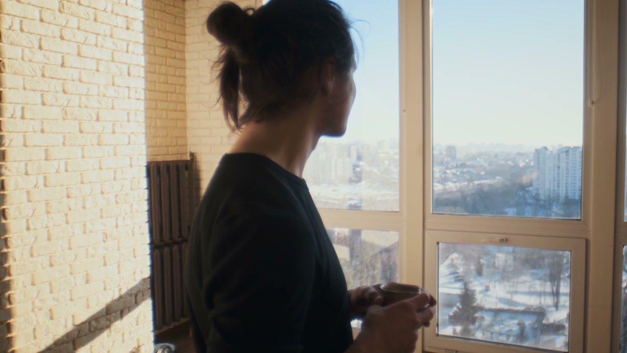 Person Drinking Coffee Looking Out City Window