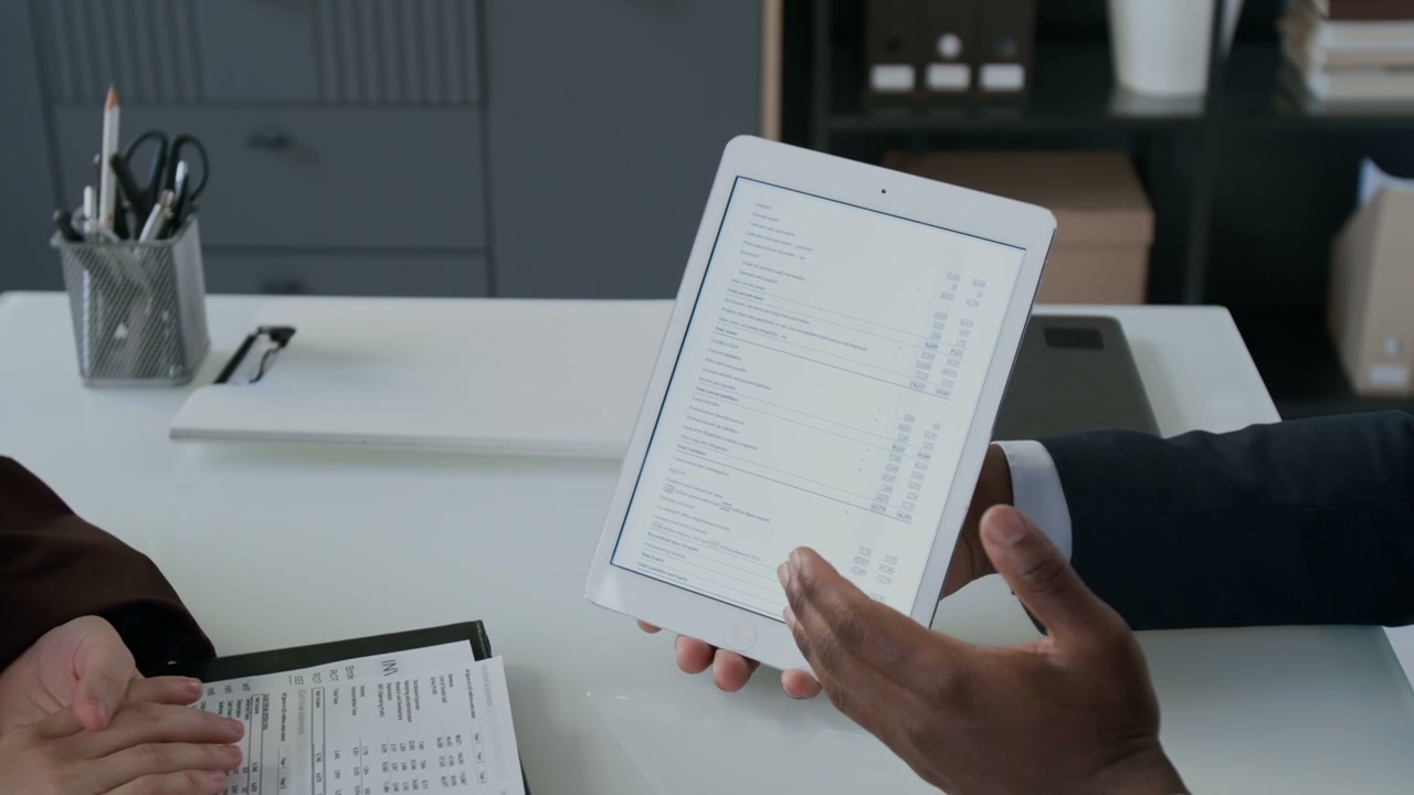 Hands Discussing Finance Data on Digital Tablet
