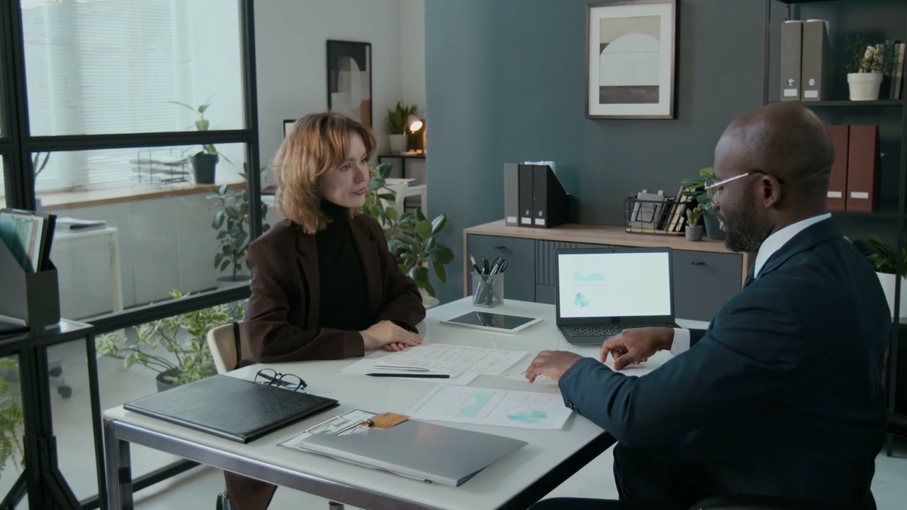Business Colleagues Exchange Documents and Shake Hands