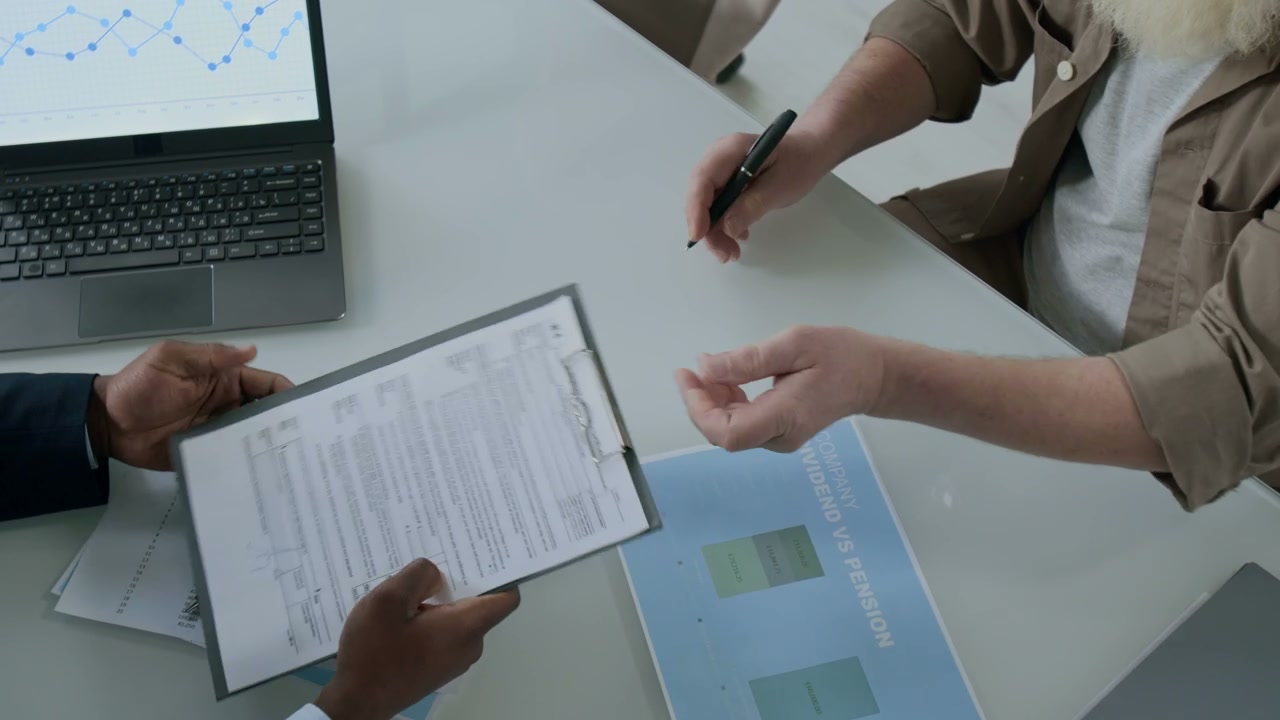 Senior Client Signs Financial Document and Shakes Hands